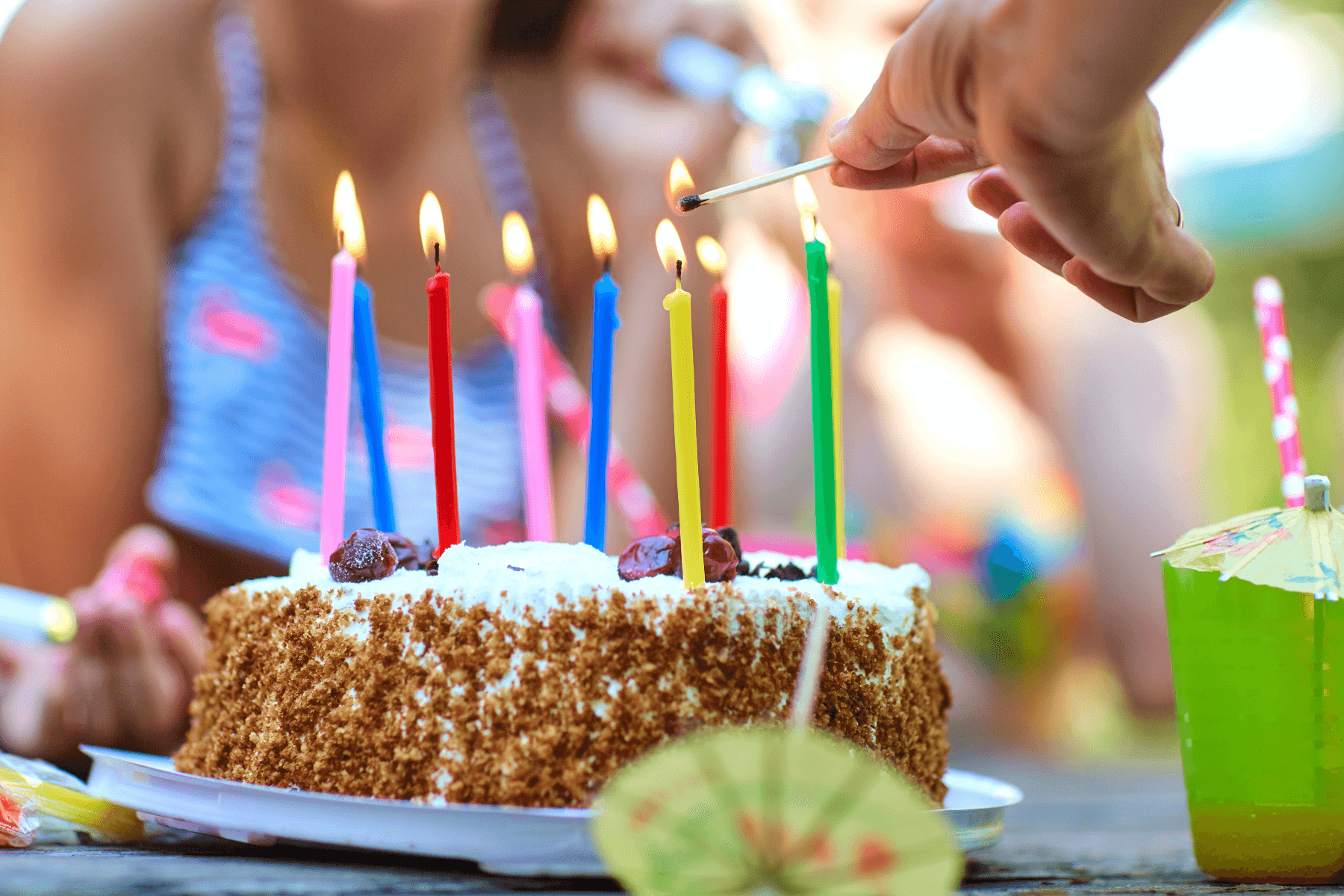 A birthday cake with candles being lit.