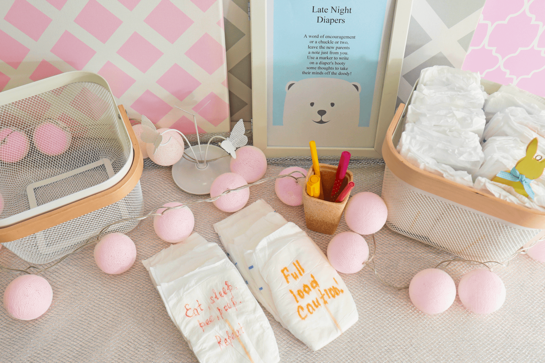 Pink and blue party decorations, diapers with messages written on them in marker.