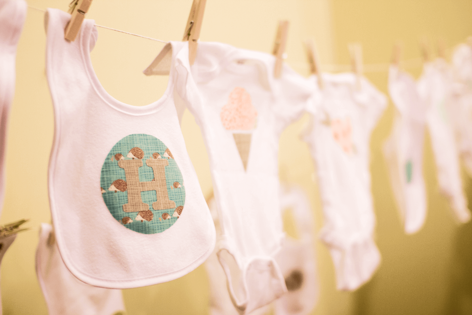 Pink baby onesies and bibs hanging on a clothes-line.