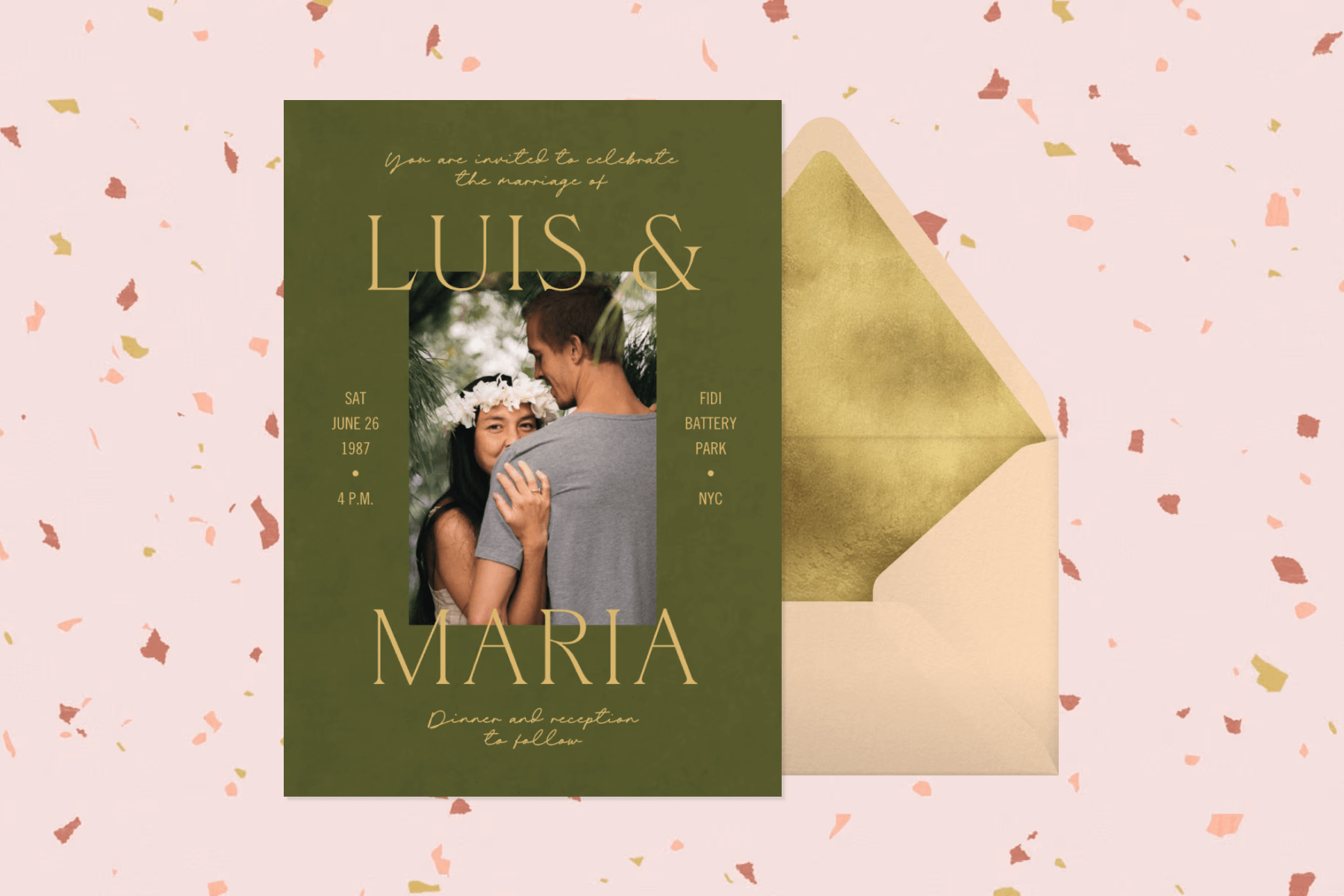 A dark green wedding invitation featuring a photo of the couple and yellow text, a peach envelope with gold liner, and a light pink background speckled with confetti. 