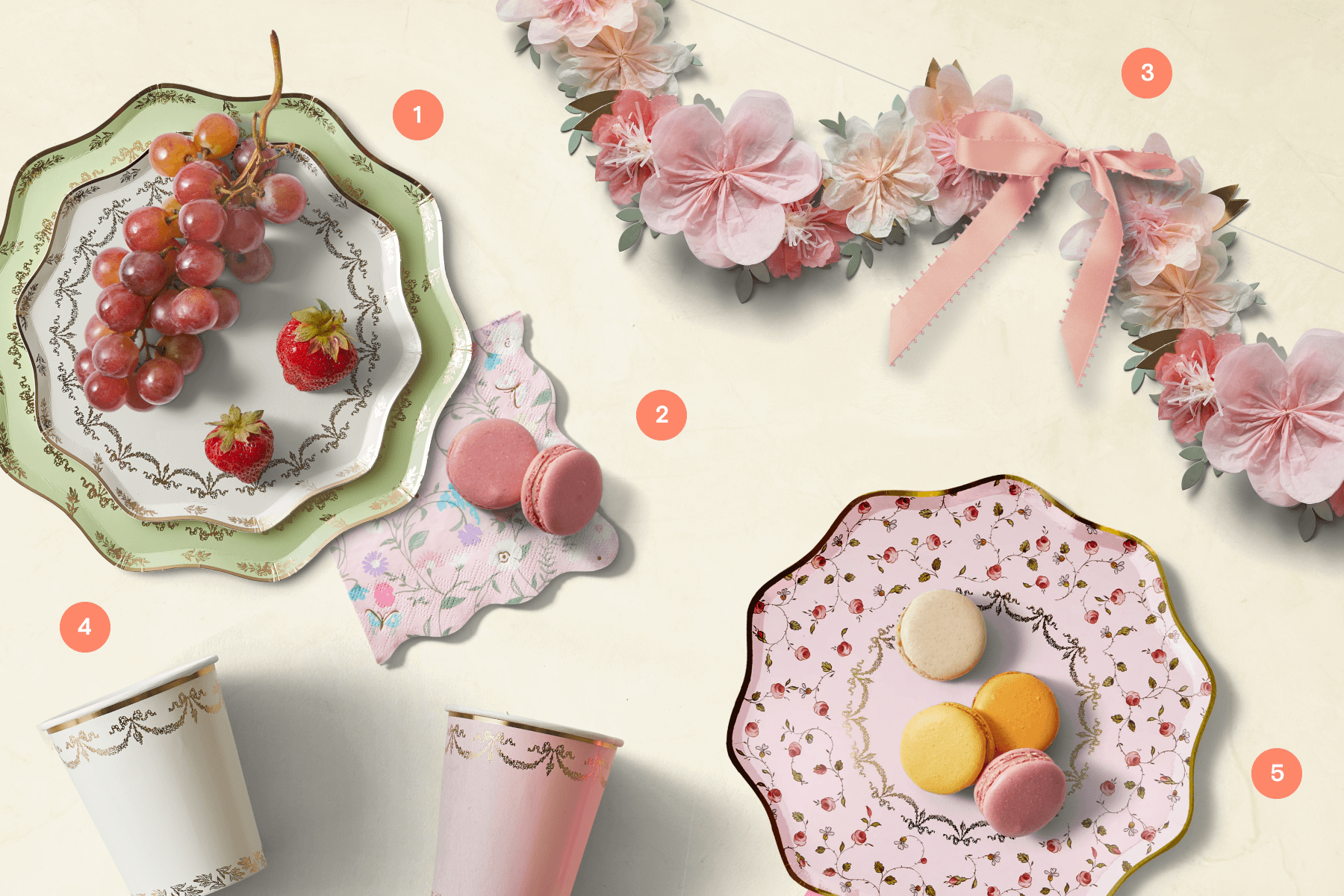 Ladurée paper plates with grapes, strawberries, and macarons, paper cups, a flower garland.