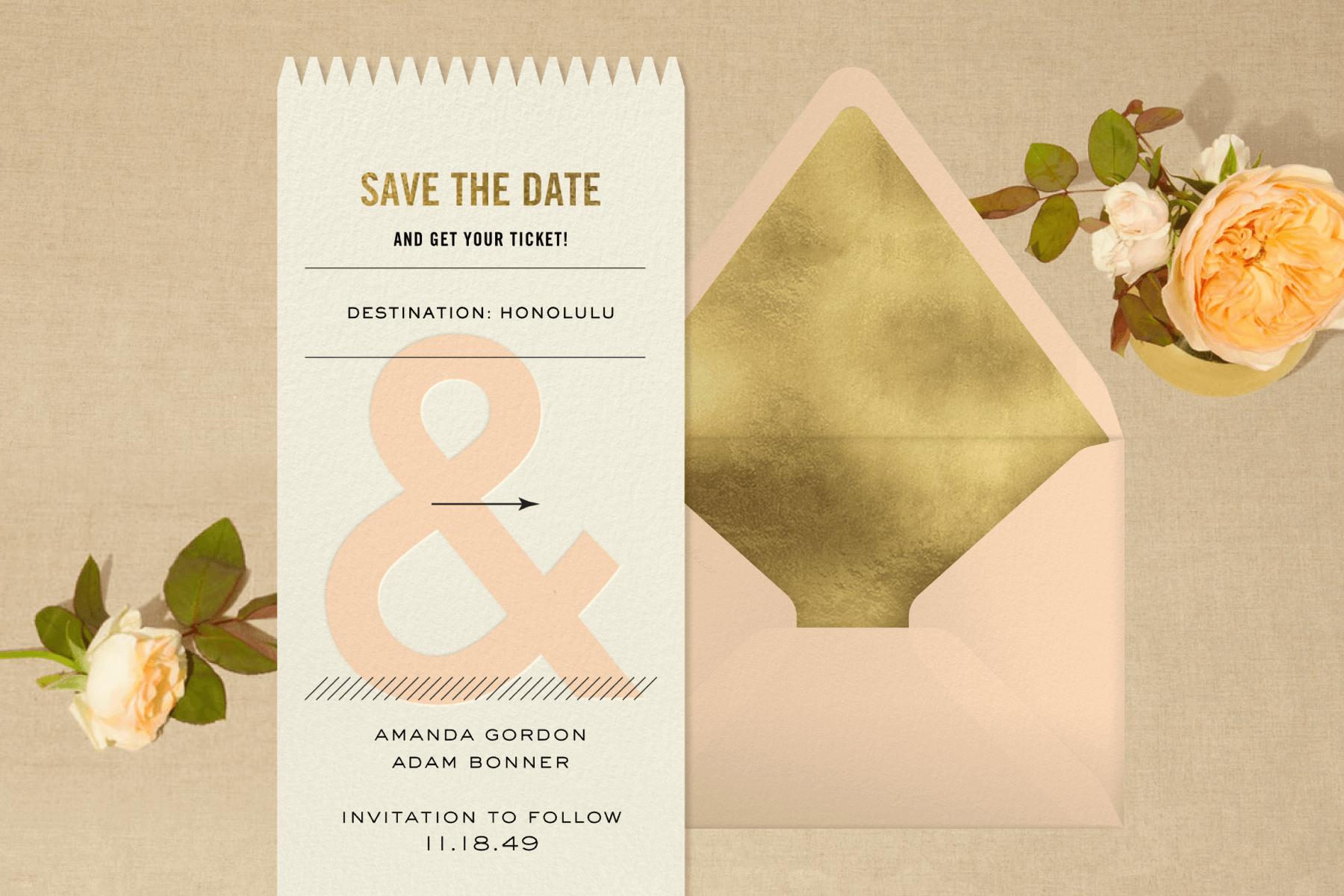 A save the date shaped like a ticket over a peach and gold envelope and peach-colored roses. 