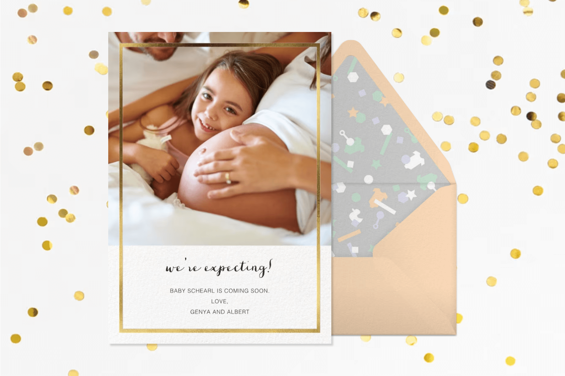 A pregnancy announcement card with a photo of a child hugging a mother’s pregnant belly next to a peach envelope and in front of a white backdrop with gold confetti.