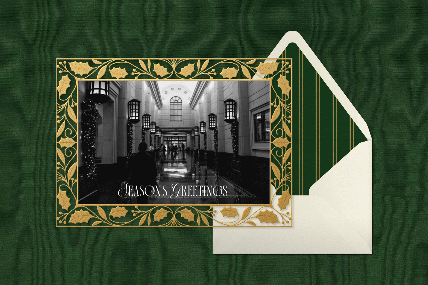 A card with a gold border and a black and white photo of a building’s interior and text reading ‘SEASON’S GREETINGS’. 