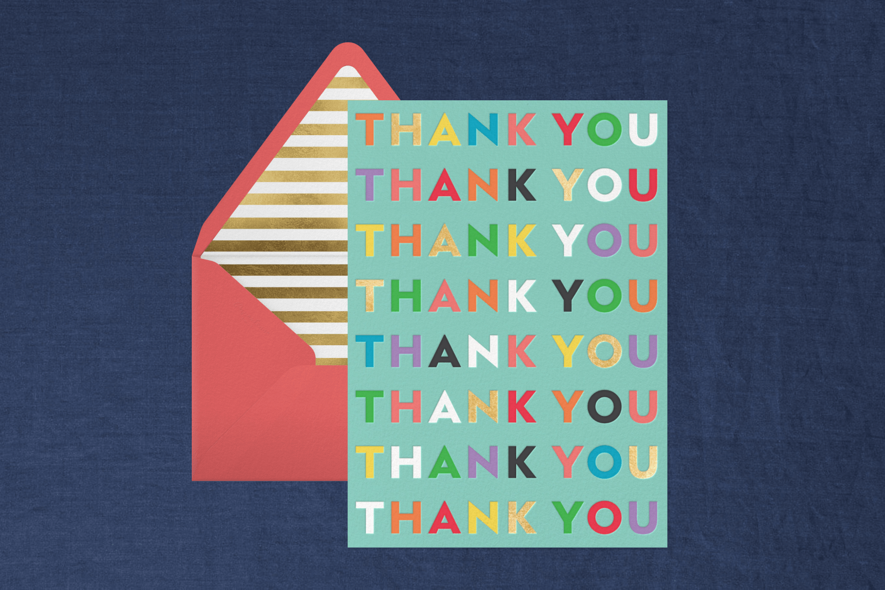 An aqua-blue thank you card with ‘THANK YOU’ written repeatedly in rainbow letters next to a pink envelope with gold striped liner on a navy backdrop.