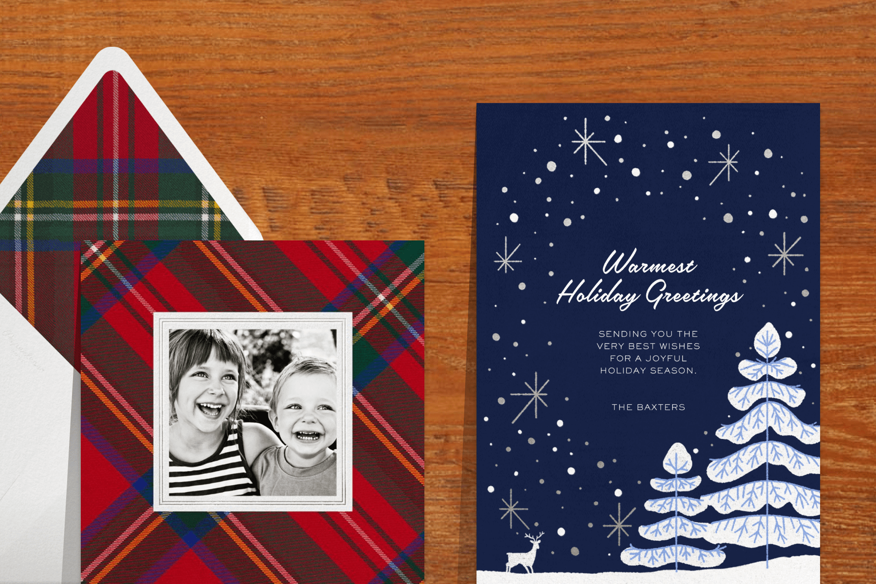 A photo card with a black and white photo of two children and a plaid border; A dark blue card with a snowy scene and text reading ‘WARMEST HOLIDAY GREETINGS’. 