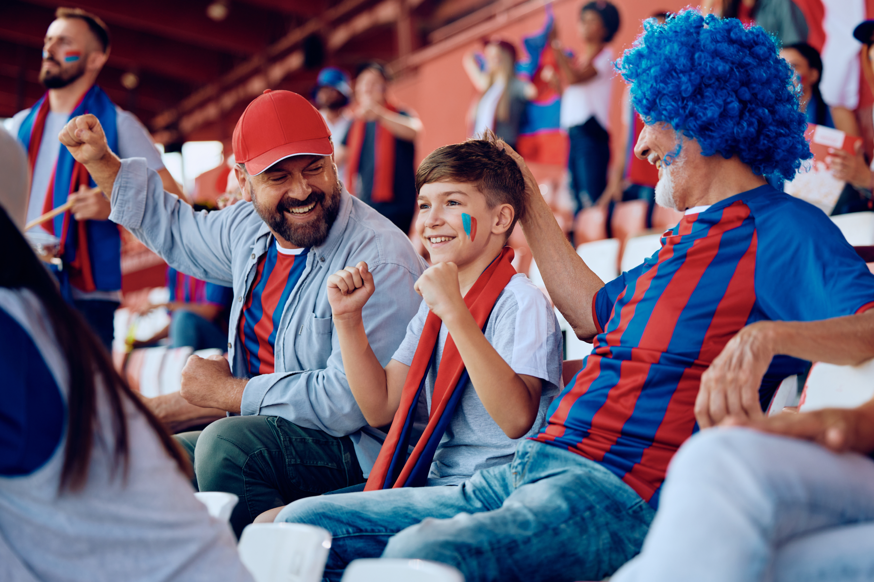 Two men and a boy enjoy a live sporting event together.